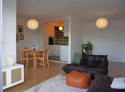 a living room with a leather couch and a table at Stijlvol App in Genk Centrum in Genk