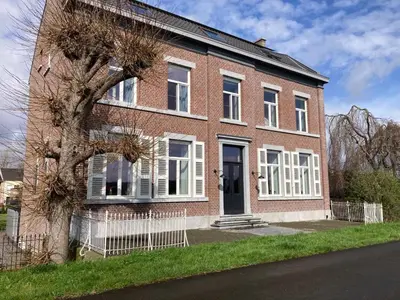 a brick house with a tree in front of it at Het Maashuis in Maasmechelen