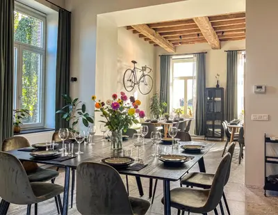 a dining room with a table and chairs at Het Maashuis in Maasmechelen