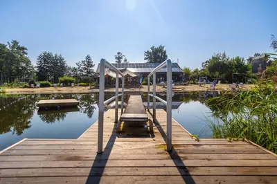 a wooden dock on a body of water at Vakantiehuis Hoge Kempen - 25 minuten Roermond, Maasmechelen & Maastricht in Kinrooi
