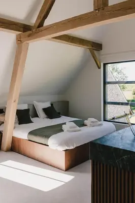 a large bed in a room with a large window at Entre Nous in Herk-de-Stad