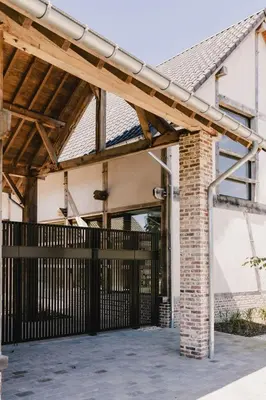 an entrance to a house with a wooden pergola at Entre Nous in Herk-de-Stad