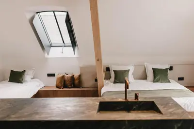 a room with two beds and a window at Entre Nous in Herk-de-Stad