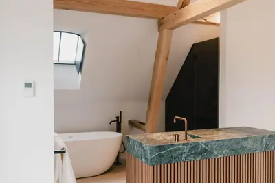 a bathroom with a sink and a bath tub at Entre Nous in Herk-de-Stad