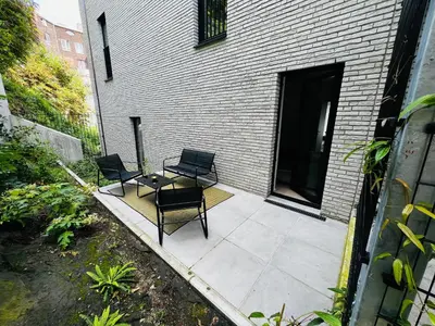 two chairs and a table on a patio at TB Trianon - Appartement Chic & Cosy in Liège