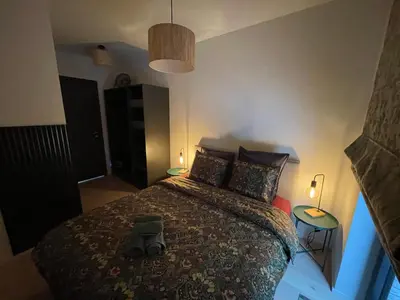 a bedroom with a bed with a backpack on it at TB Trianon - Appartement Chic & Cosy in Liège