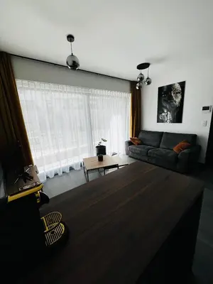a living room with a couch and a table at TB Trianon - Appartement Chic & Cosy in Liège