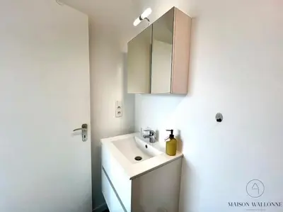 a white bathroom with a sink and a mirror at Le Panoramique des Carmes - Vue Cathédrale in Liège