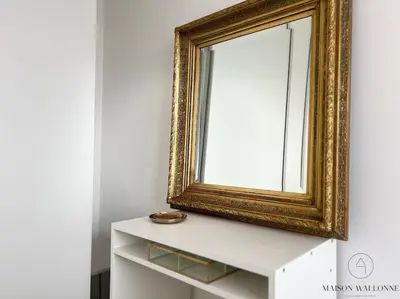 a mirror sitting on top of a white dresser at Le Panoramique des Carmes - Vue Cathédrale in Liège