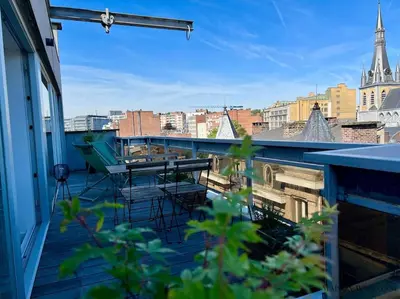 a balcony with tables and chairs on a building at Le Panoramique des Carmes - Vue Cathédrale in Liège