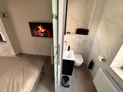 a bathroom with a bed and a fire in the wall at FourSuites Liège in Liège