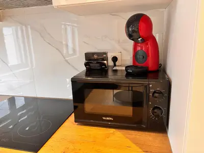 a red appliance sitting on top of a microwave at FourSuites Liège in Liège