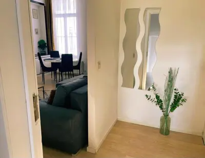 a living room with a green couch and a table at Au coeur du théâtre in Verviers