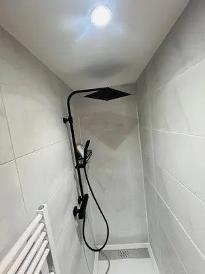 a shower in a bathroom with a light on the ceiling at Maison d’Ans in Ans