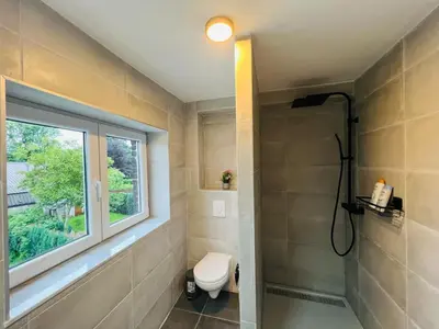 a bathroom with a toilet and a window at Maison d’Ans in Ans