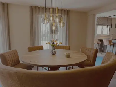 a dining room table with chairs and a vase of flowers at Vakantievilla 't Boshuys in Lommel