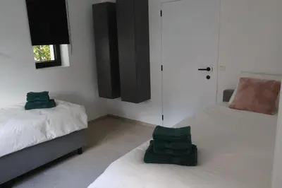 a bedroom with two beds with green towels on them at Maas & Me in Dilsen-Stokkem