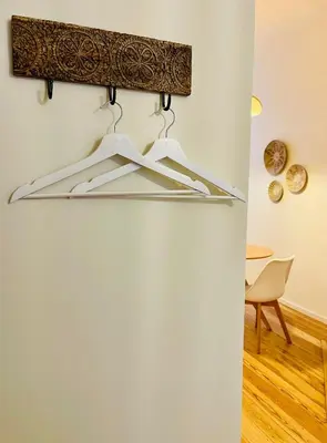a hanger in a room with a table and a chair at Chaleureux petit appartement in Liège
