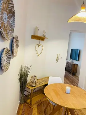 a dining room with a wooden table and a heart on the wall at Chaleureux petit appartement in Liège
