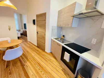 a kitchen with a sink and a table in a room at Chaleureux petit appartement in Liège