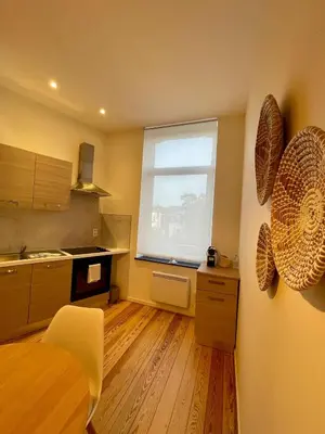 a kitchen with a window and a wooden floor at Chaleureux petit appartement in Liège