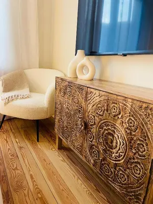 a living room with a chair and a television at Chaleureux petit appartement in Liège