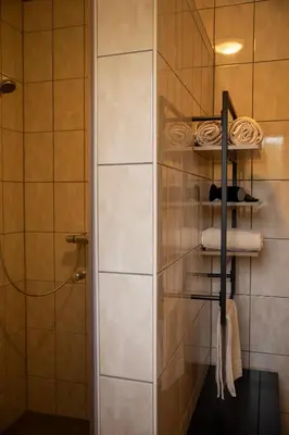 a towel rack in a bathroom with a shower at Tussen Heide en Bos in het Nationaal Park Hoge Kempen in Oudsbergen
