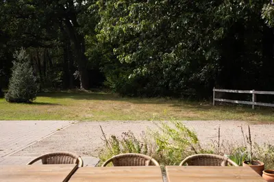 a picnic table with two chairs and a bench in a park at Tussen Heide en Bos in het Nationaal Park Hoge Kempen in Oudsbergen