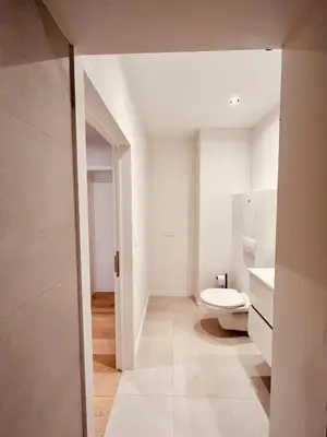 a white bathroom with a toilet and a sink at Cosy Of John Cockerill in Seraing