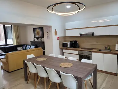 a kitchen and living room with a wooden table and chairs at Biesenbilzen in Bilzen