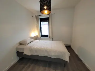 a small bedroom with a bed and a window at Biesenbilzen in Bilzen