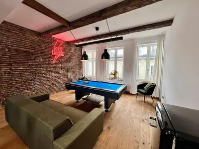 a living room with a pool table and a brick wall at Grande Maison au cœur du Carré - Quartier Festif! in Liège