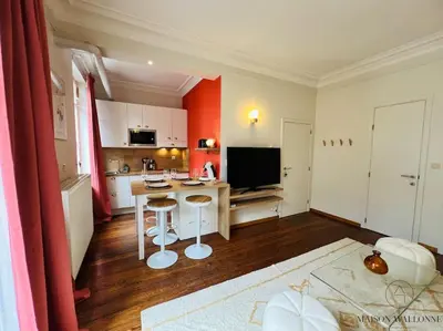 a living room with a table and a kitchen at L'haussmanien romantique - HEC, Jardin botanique in Liège