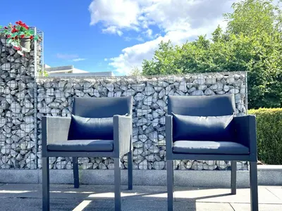 two chairs sitting in front of a stone wall at t Vennehuisje in Genk