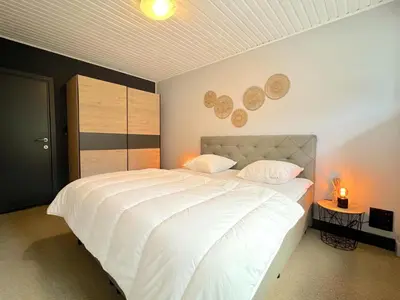 a bedroom with a large white bed with two pillows at t Vennehuisje in Genk