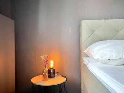 a small table with a candle on it next to a bed at t Vennehuisje in Genk