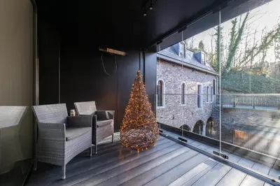 a christmas tree in a room with a large window at De Droomhoeve in Bilzen