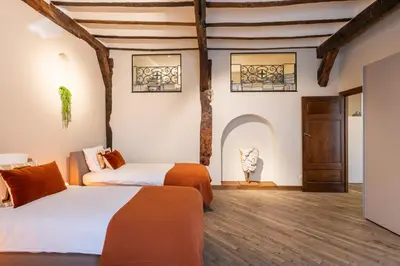 two beds in a room with wooden floors and ceilings at De Droomhoeve in Bilzen