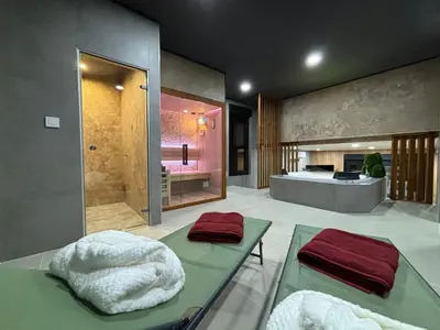 a bathroom with a shower and a tub with towels at Pause Thermale Suites Deluxe et Spa Privatif in Herstal