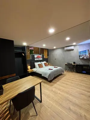 a bedroom with a bed and a table in it at Pause Thermale Suites Deluxe et Spa Privatif in Herstal