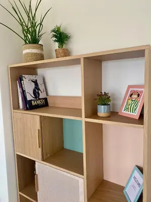 a wooden book shelf with books and plants at Skylodgenk in Genk
