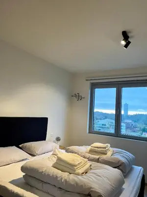 two beds in a room with a large window at Skylodgenk in Genk