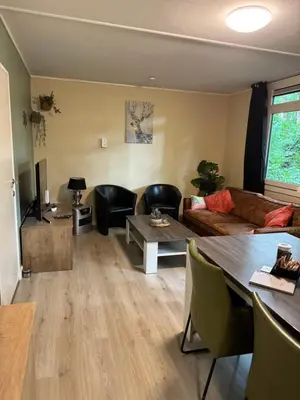 a living room with a couch and a table at Infinity met hottub op Jocomo Park in Lanaken
