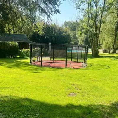 a batting cage in a park with green grass at Infinity met hottub op Jocomo Park in Lanaken