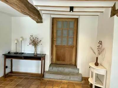 a wooden door in a room with a table and stairs at Gite 13 personnes in Battice