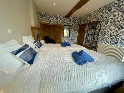 a bedroom with a large white bed with blue pillows at Gite 13 personnes in Battice