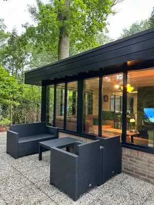 a glass house with a bench and a table at Vakantiehuis Lanaken in Lanaken
