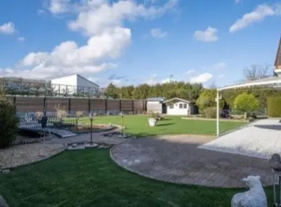 a yard with a building and a field of grass at Villa kleinwellness in Lanaken