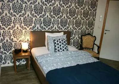 a bedroom with a bed and a wall with wallpaper at B&B Horpala in Heers
