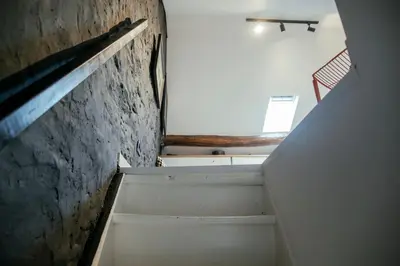 a staircase in a room with a window and a wall at La Courte Échelle in Verviers